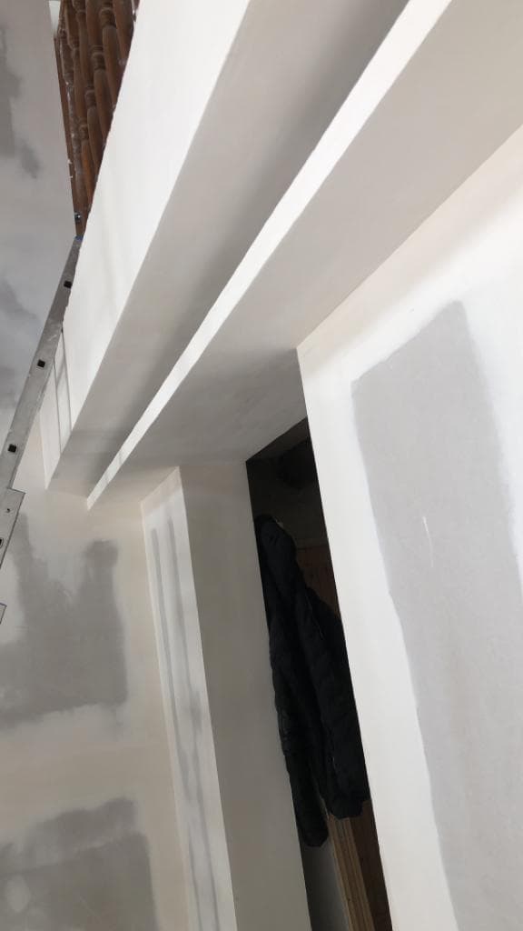 Caissons de faux-plafond en plaques de plâtre à Ferney-Voltaire, joints repris par bandes et enduit avant peinture, près de balustres anciens en bois tourné